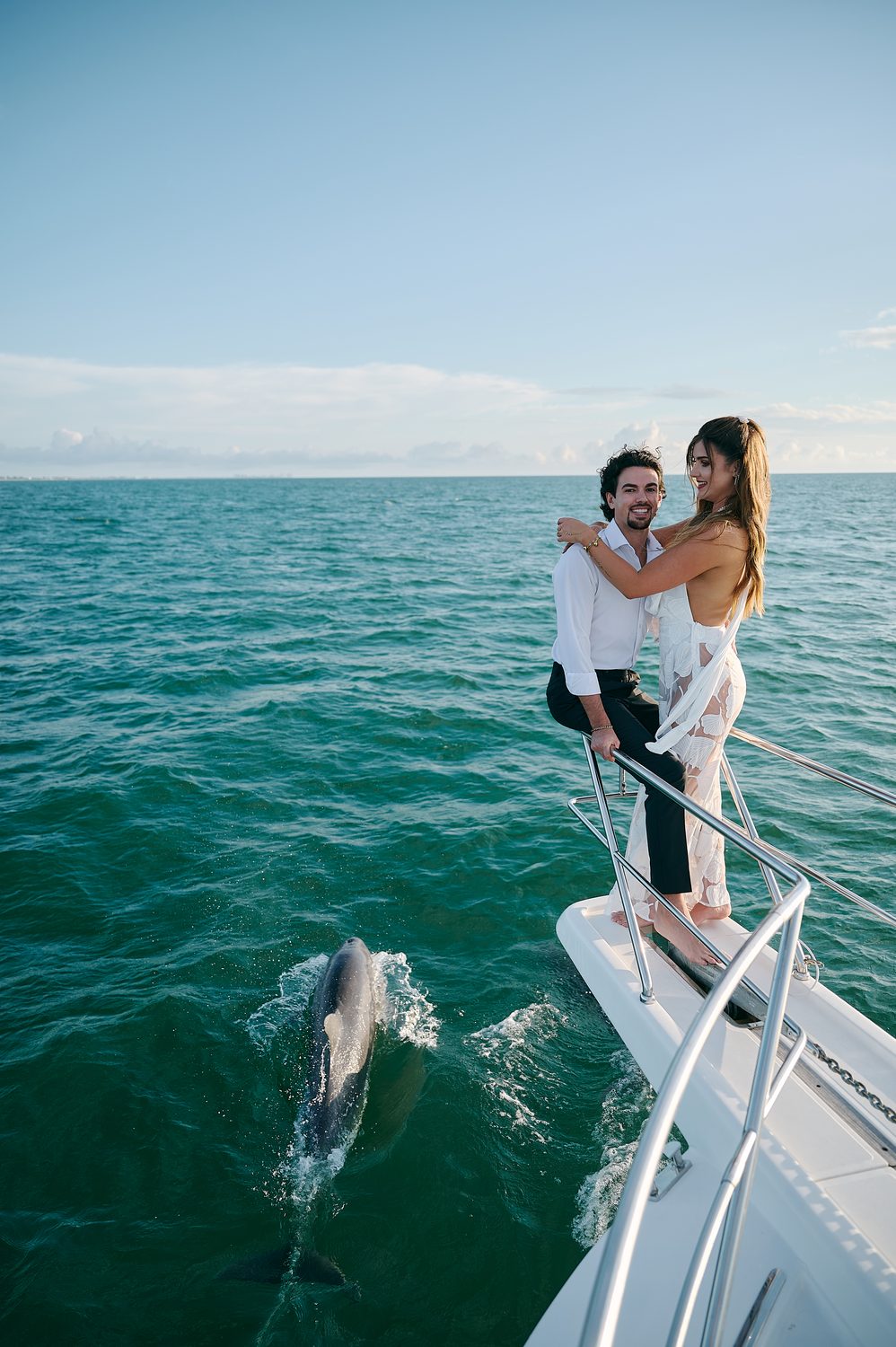 Holding each other on the bow, the open ocean around them