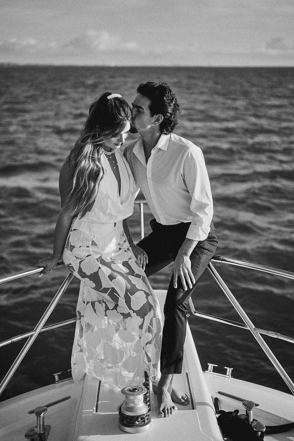 A kiss on the open ocean, in moody black and white