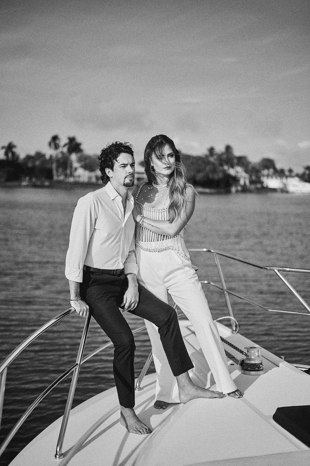 Standing on the bow against the island skyline, in black and white