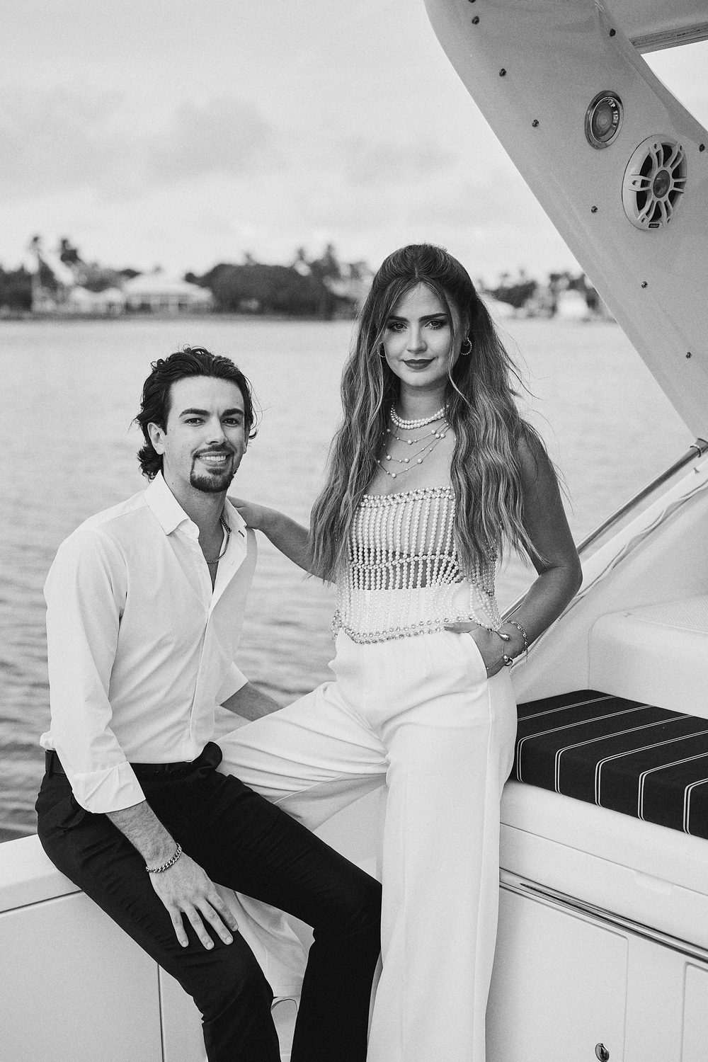 A posed portrait at sea, the island skyline beyond, in black and white